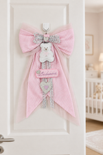 Fiocco nascita con tulle rosa tenue sulla porta di una cameretta