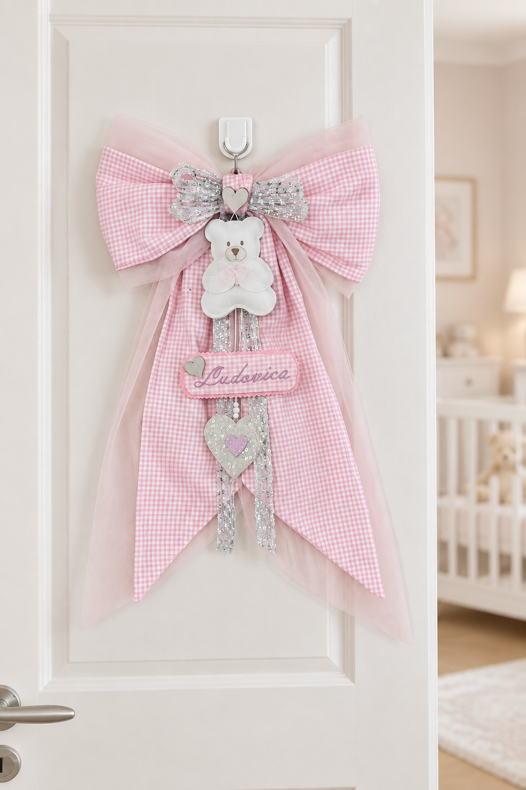 Fiocco nascita con tulle rosa tenue sulla porta di una cameretta